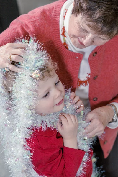 Mormor och barnbarn dekorera julgran — Stockfoto