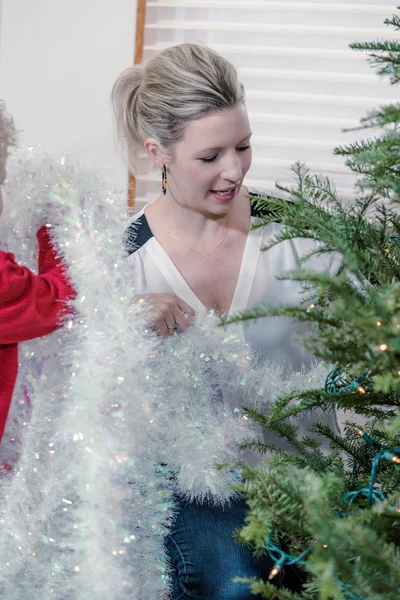 Schöne Frau schmückt Weihnachtsbaum — Stockfoto