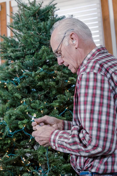 Grandfather decorating Christmas tree — Stock Photo, Image