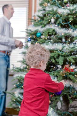 Baba ve oğul Noel ağacı süslüyorlar.