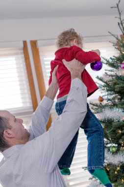 Baba ve oğul Noel ağacı süslüyorlar.