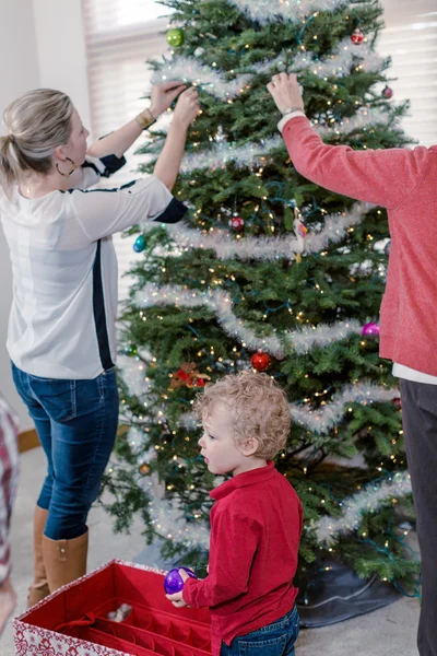 Familie schmückt Weihnachtsbaum. — Stockfoto