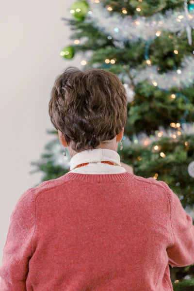 Grandmother decorating Christmas tree — Stock Photo, Image