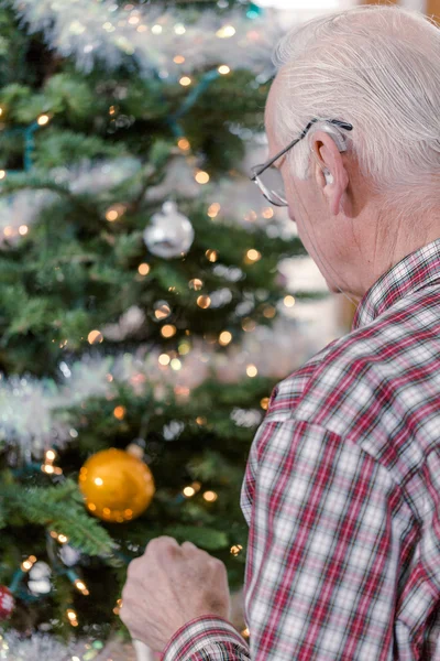 Grandfather decorating Christmas tree — Stock Photo, Image