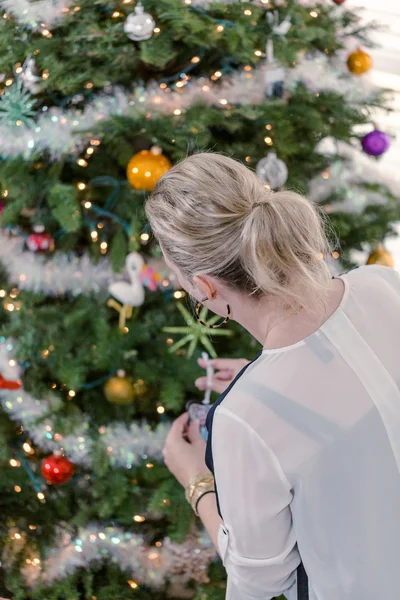Beautiful woman decorating Christmas tree — Stock Photo, Image