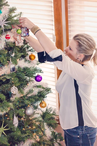 Krásná žena zdobí vánoční stromek — Stock fotografie