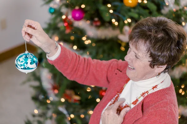 Grandmother decorating Christmas tree — Stock Photo, Image