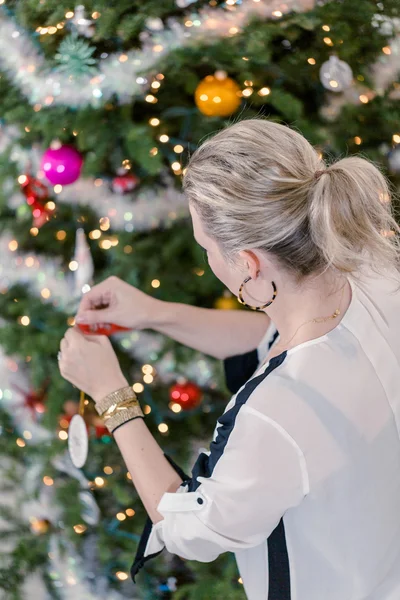 Beautiful woman decorating Christmas tree — Stock Photo, Image