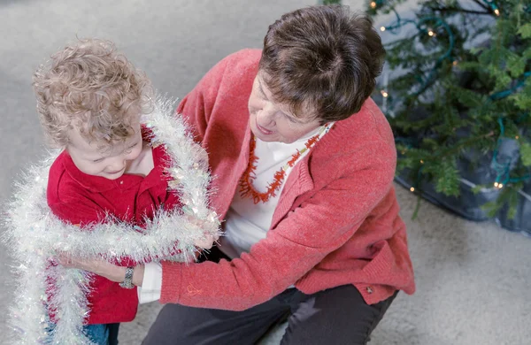 Mormor och barnbarn dekorera julgran — Stockfoto