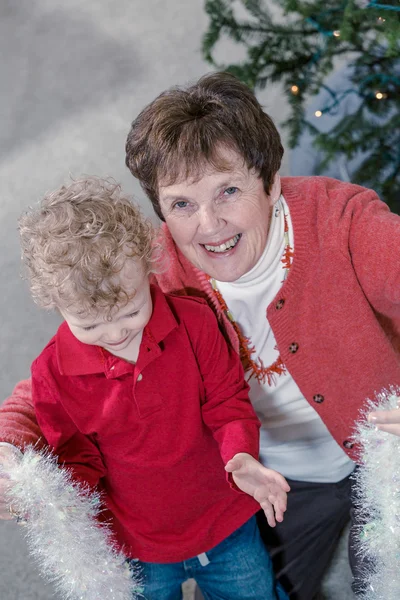 Mormor och barnbarn dekorera julgran — Stockfoto