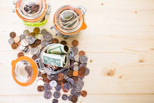 Saving money into glass jars — Stock Photo, Image