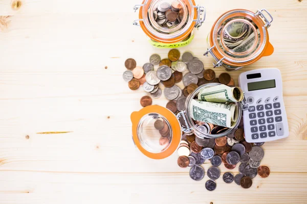 Saving money into glass jars — Stock Photo, Image