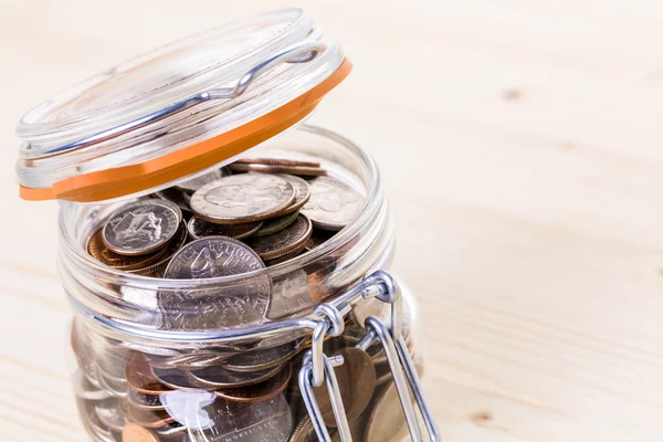 Saving money into glass jar — Stock Photo, Image