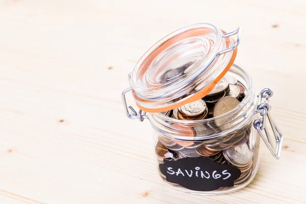 Saving money into glass jar — Stock Photo, Image