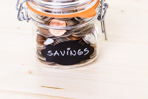 Saving money into glass jar — Stock Photo, Image