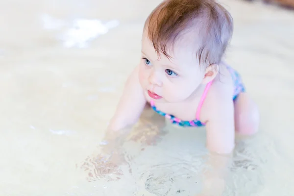 Baby girl at indoor swimming pool — Stock Photo, Image