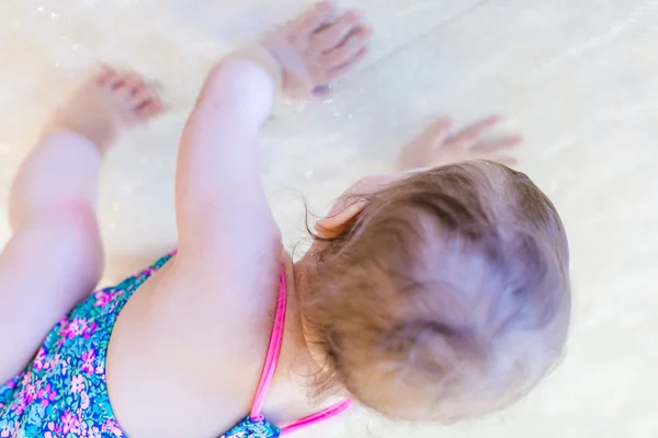 Baby girl at indoor swimming pool — Stock Photo, Image