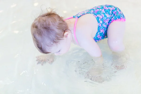 Baby girl at indoor swimming pool — Stock Photo, Image