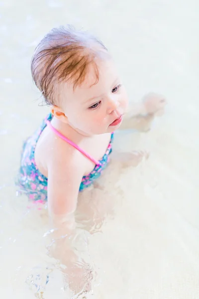 Baby girl at indoor swimming pool — Stock Photo, Image