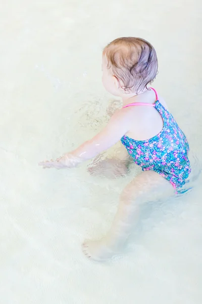 Baby girl at indoor swimming pool — Stock Photo, Image