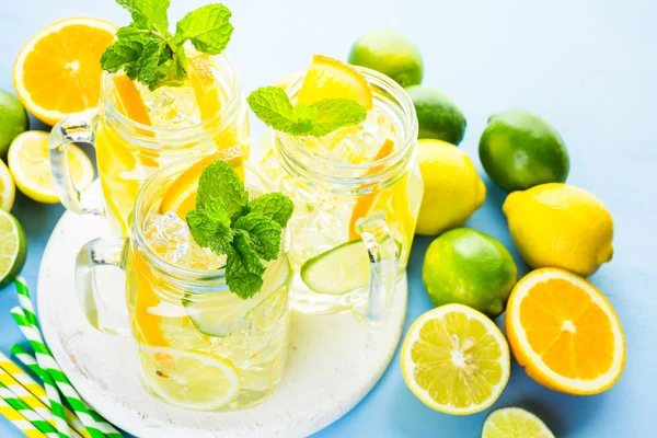 Water with fresh citrus fruits and ice — Stock Photo, Image