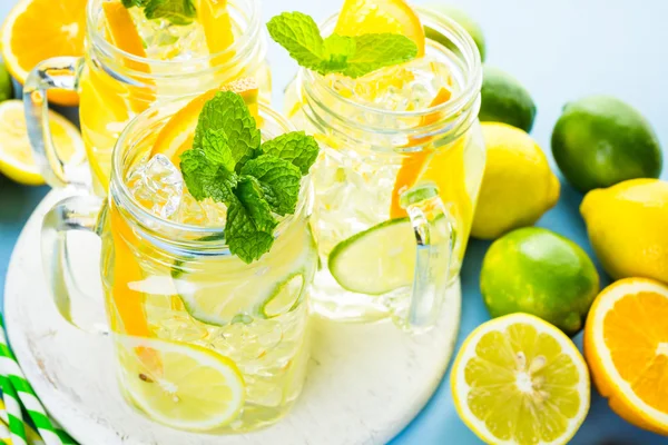 Water with fresh citrus fruits and ice — Stock Photo, Image