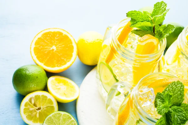 Water with fresh citrus fruits and ice — Stock Photo, Image