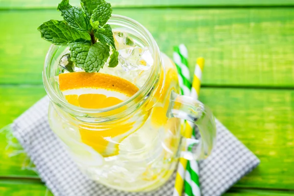 Water with fresh citrus fruits and ice — Stock Photo, Image