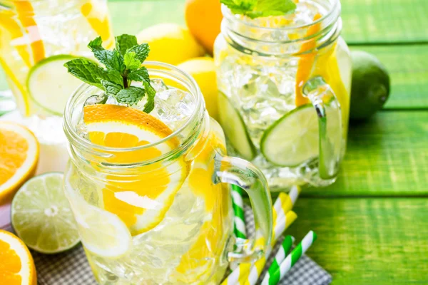 Water with fresh citrus fruits and ice — Stock Photo, Image