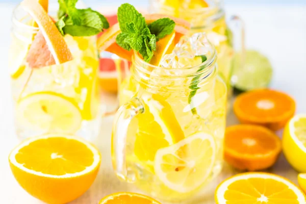 Water with fresh citrus fruits and ice — Stock Photo, Image