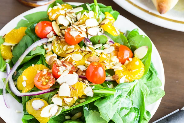 Orange spinach salad on the plate — Stock Photo, Image