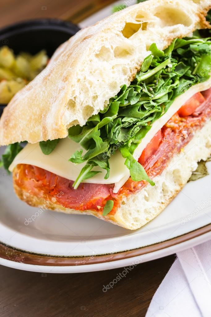 Italian sub sandwich with arugula — Stock Photo © urban_light 74634725