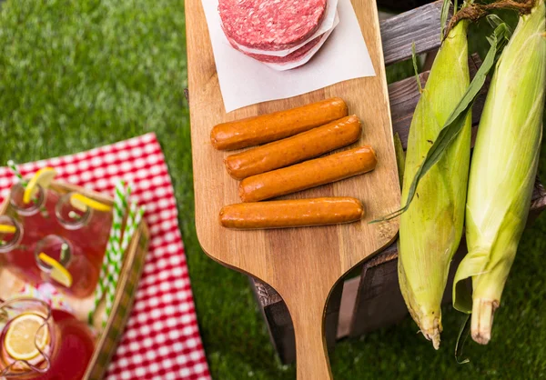 Summer picnic with small charcoal grill and hotdogs — Stock Photo, Image