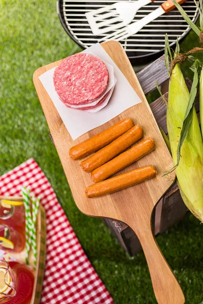 Summer picnic with small charcoal grill and hotdogs — Stock Photo, Image