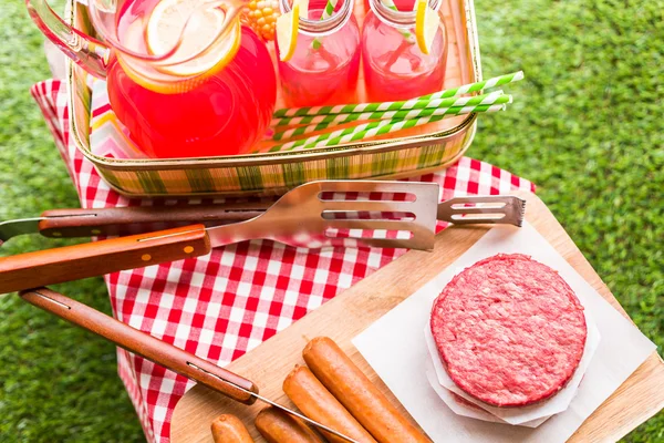 Summer picnic with lemonade and hamburger patties — Stock Photo, Image