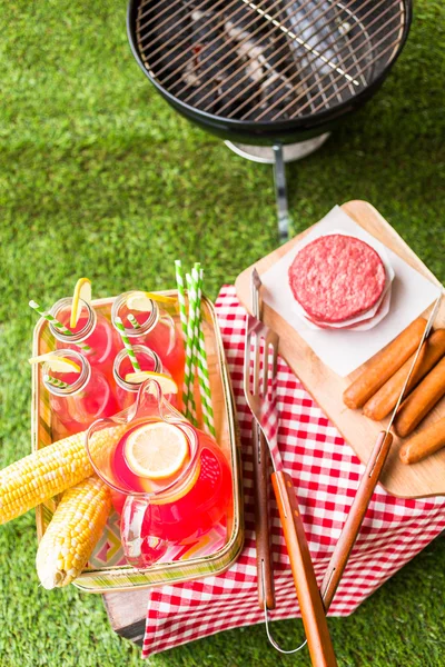 Summer picnic with lemonade and hamburger patties — Stock Photo, Image