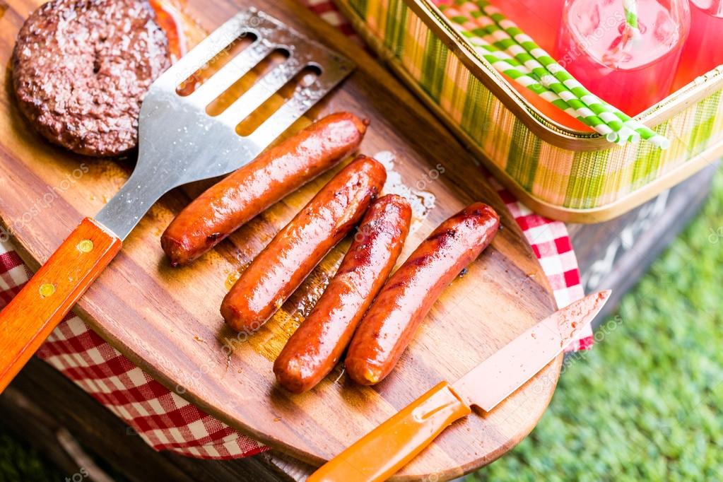 Summer picnic, hot dogs, lemonade and hamburger patties Stock Photo by
