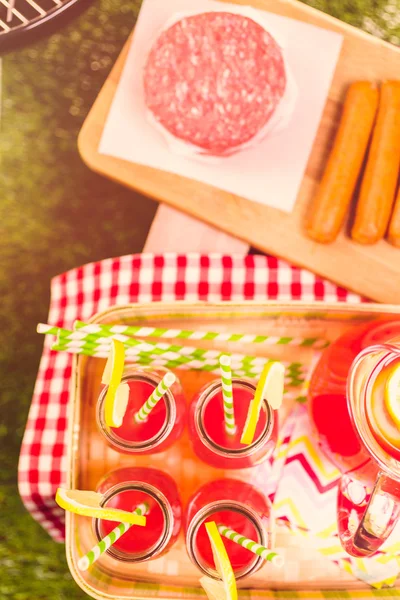 Summer picnic with lemonade and hamburger patties — Stock Photo, Image