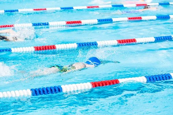 Crianças nadam se encontram na piscina exterior — Fotografia de Stock