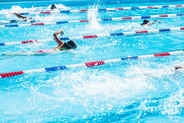 Crianças nadam se encontram na piscina exterior — Fotografia de Stock