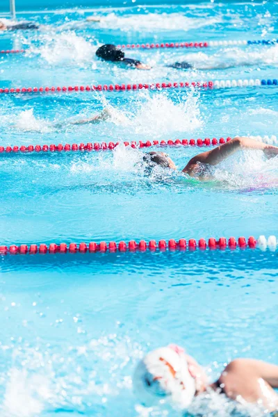 Crianças nadam se encontram na piscina exterior — Fotografia de Stock