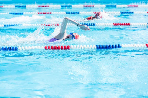 Crianças nadam se encontram na piscina exterior — Fotografia de Stock