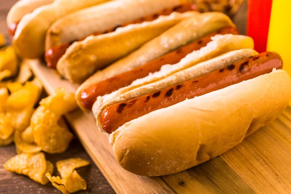 Cachorros-quentes grelhados em um cachorro-quente branco — Fotografia de Stock