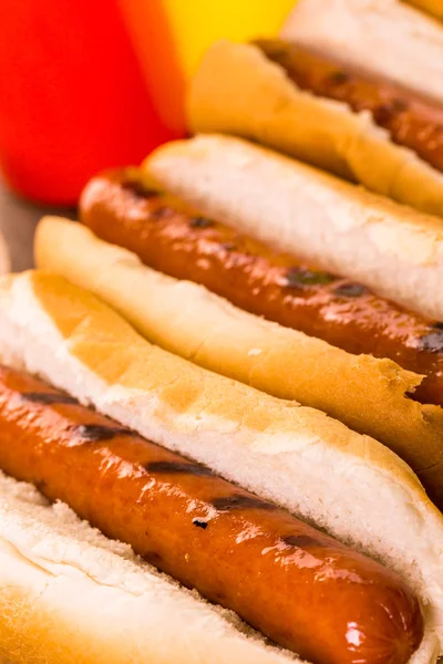 Cachorros-quentes grelhados em um cachorro-quente branco — Fotografia de Stock