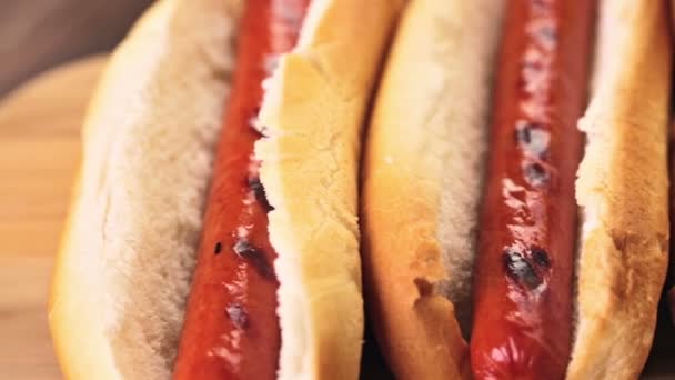 Gegrilde hotdogs op een witte hot dog buns — Stockvideo