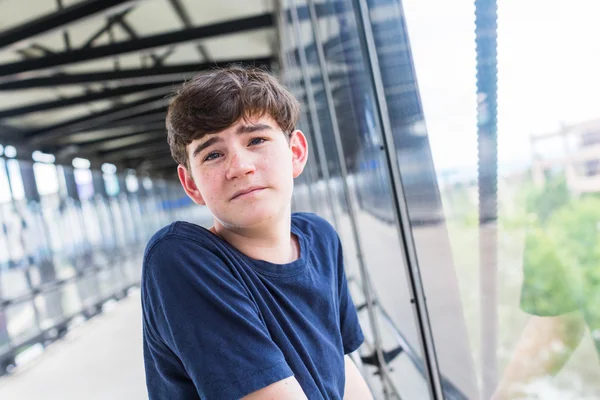 Ragazzo adolescente alla stazione ferroviaria leggera — Foto Stock