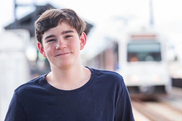 Ragazzo adolescente alla stazione ferroviaria leggera — Foto Stock