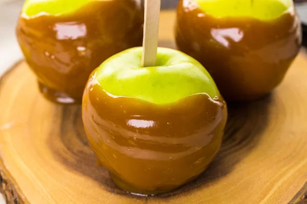 Maçãs e caramelo na mesa — Fotografia de Stock