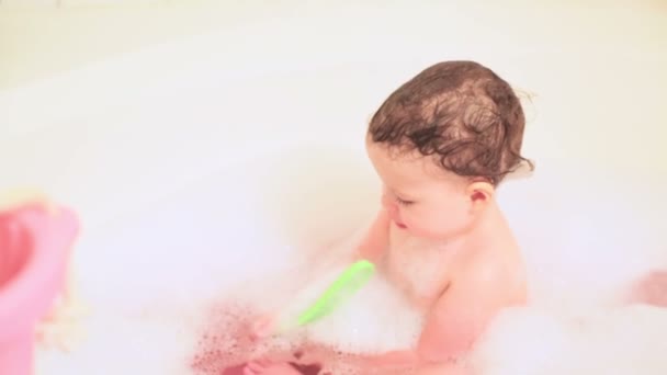 Kleines Mädchen badet in einer Badewanne mit Spielzeug — Stockvideo
