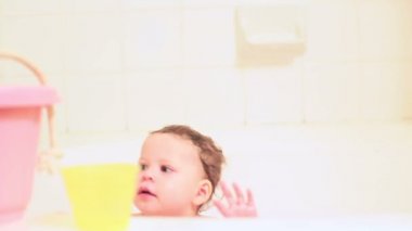 küçük kız oyuncakları ile bir banyoda hidromasajlı küvet